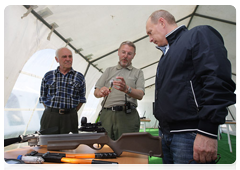 Devices used by scientists to research white whale behaviour and migrations being demonstrated to Vladimir Putin in a field tent