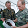 Vycheslav Rozhnov, a deputy director of the Severtsov Institute of Ecology and Evolution, showing Vladimir Putin a satellite-tracked collar with a GPS navigator which researchers fasten around the captured tiger’s neck