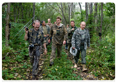 Vladimir Putin and a group of researchers going to the taiga to see the trapped tigress
