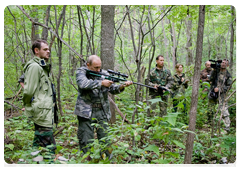 Vladimir Putin takes a shot from an air rifle at the tigress who managed to escape from the steel loop. A syringe with a tranquilliser hits the animal