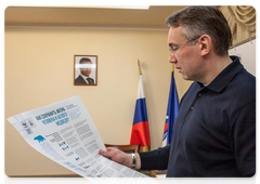 Nenets Autonomous Area Governor Igor Koshin receives an instructrion/ guide poster on polar bear conservation