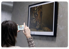 A forum participant takes a picture of a photo at the exhibition