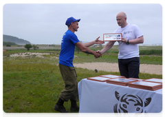 Amur Tiger Centre Director General Sergei Aramilev presents a certificate to a participant of the Tiger student team’s fourth session